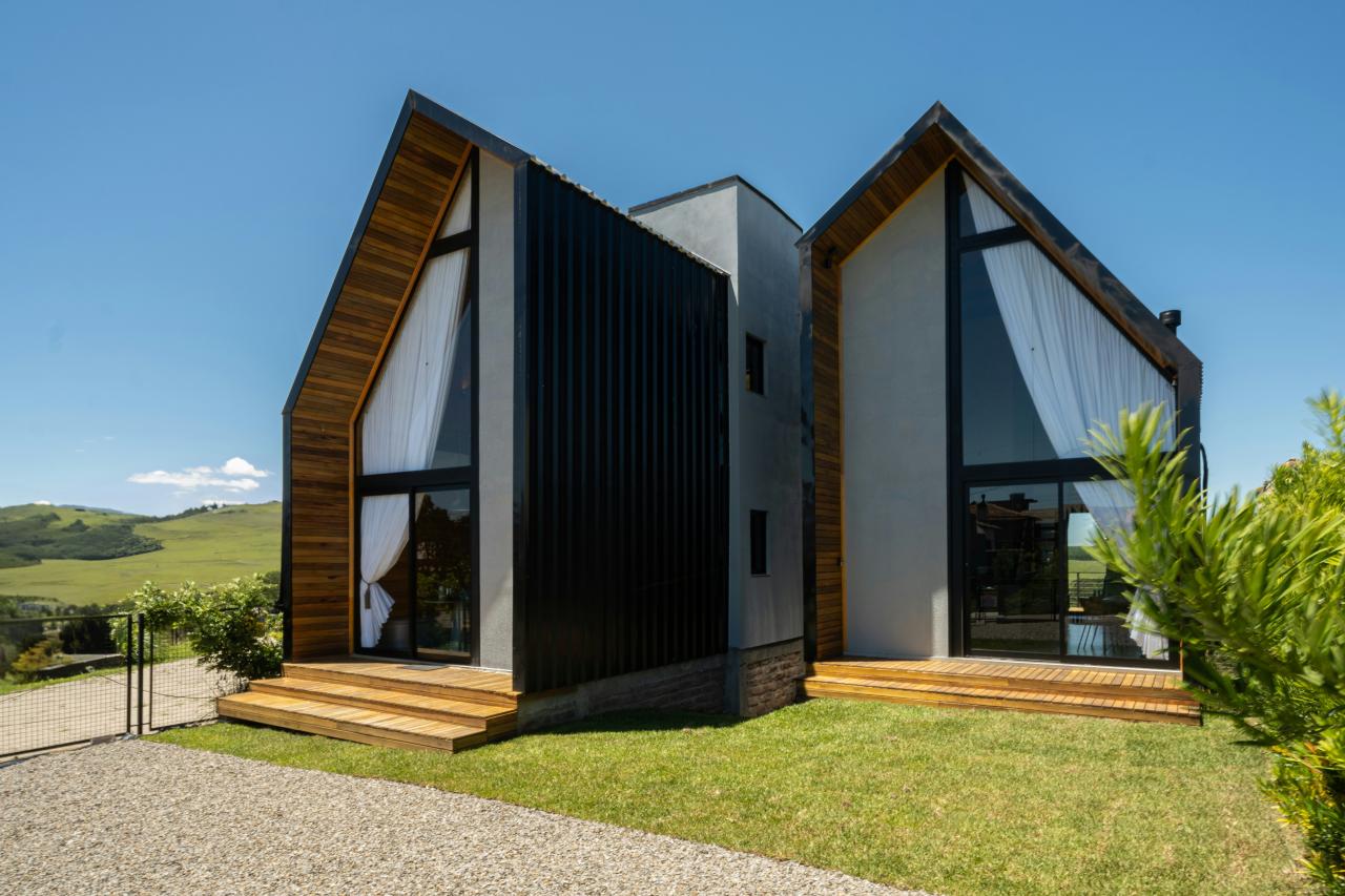 Modern a-frame house with large windows and wooden accents.